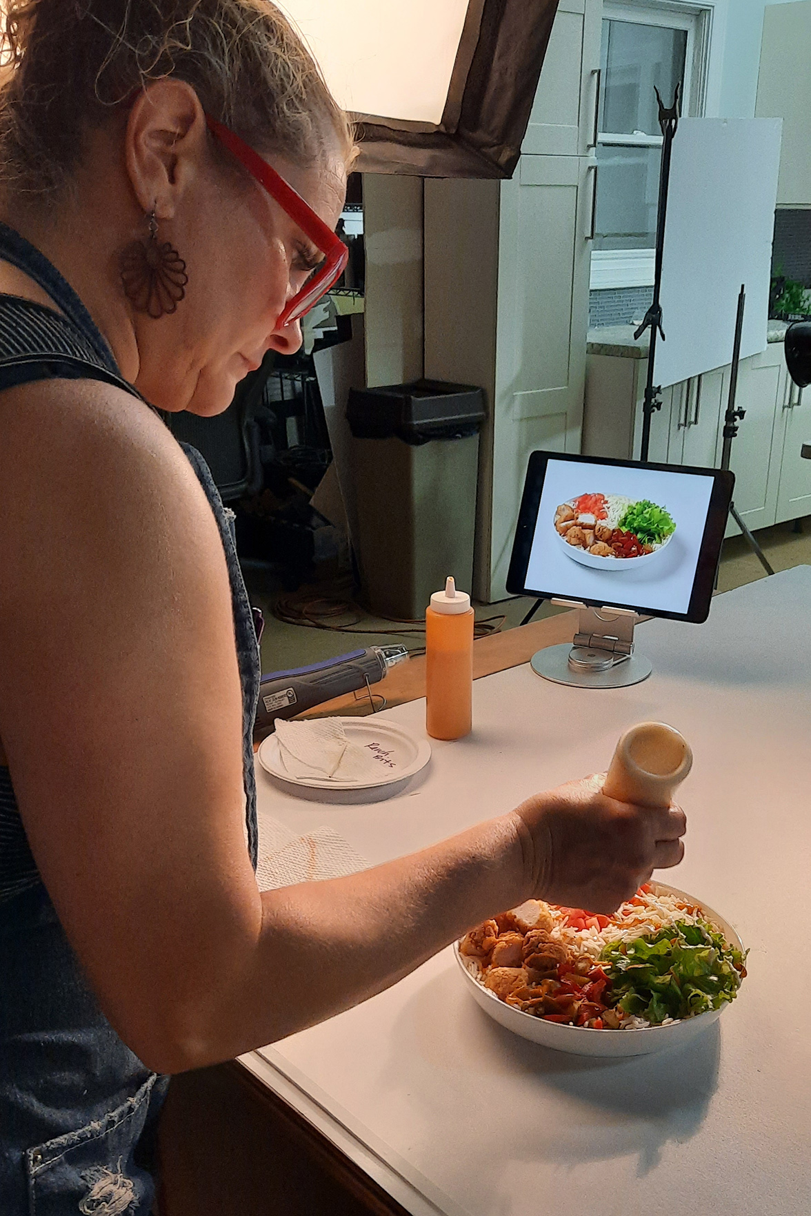 Atlanta food stylist Vanessa Parker dresses a salad bowl on set.